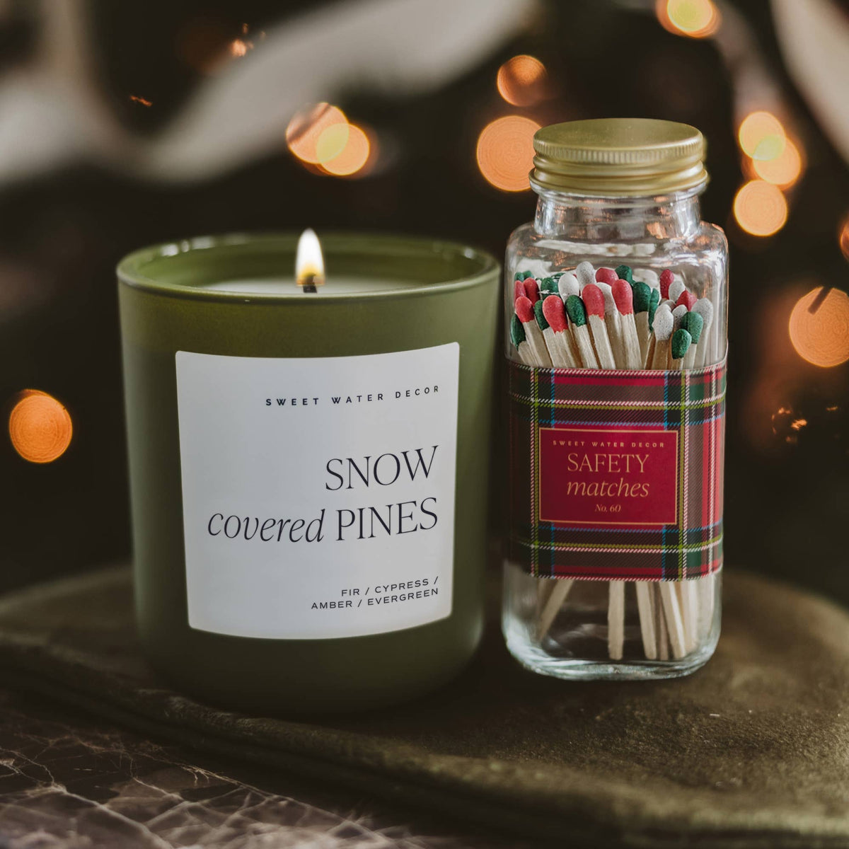 Holiday plaid safety matches beside a green Christmas candle