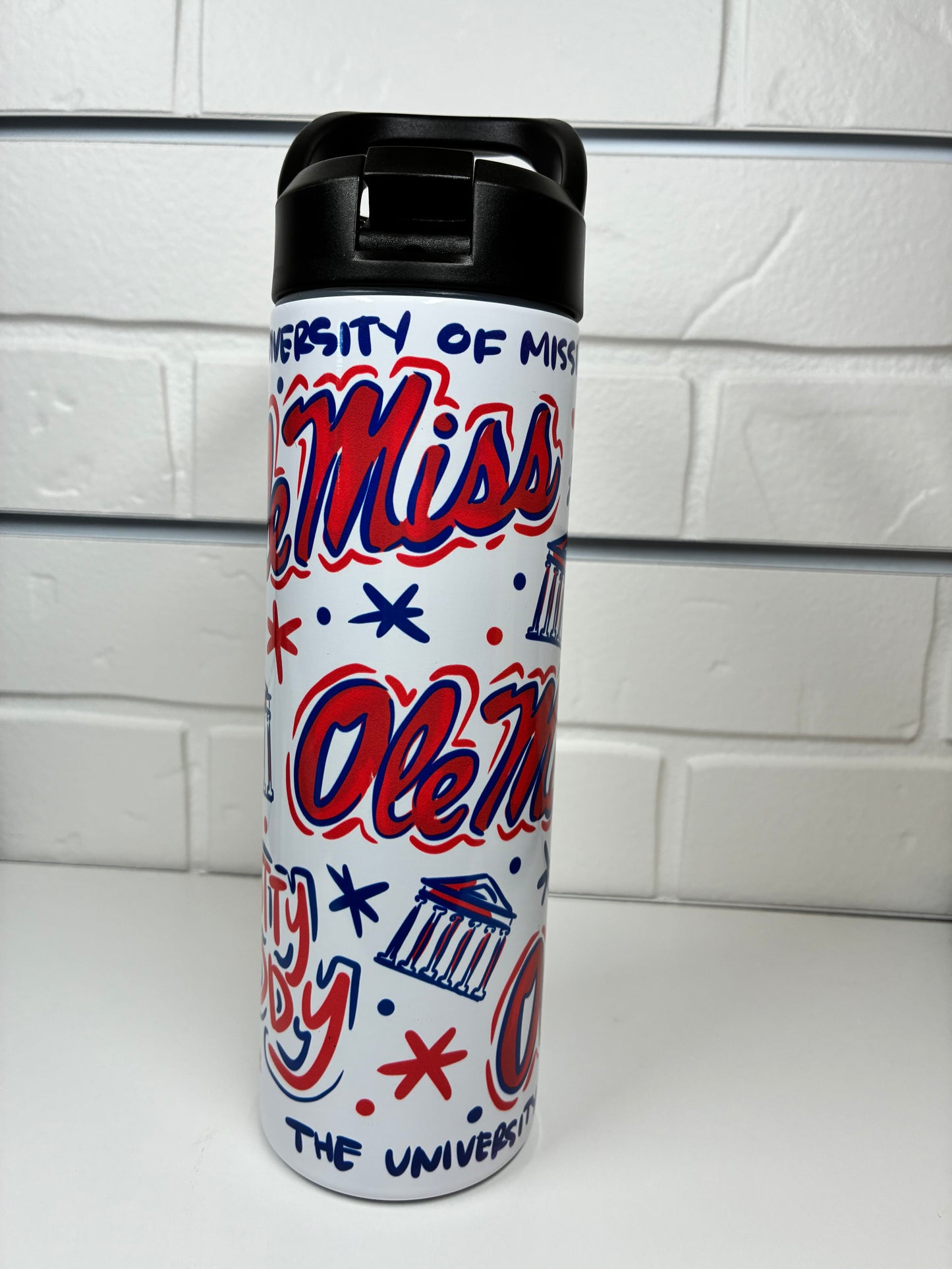 Water bottle with 'Ole Miss' design on a white tiled background