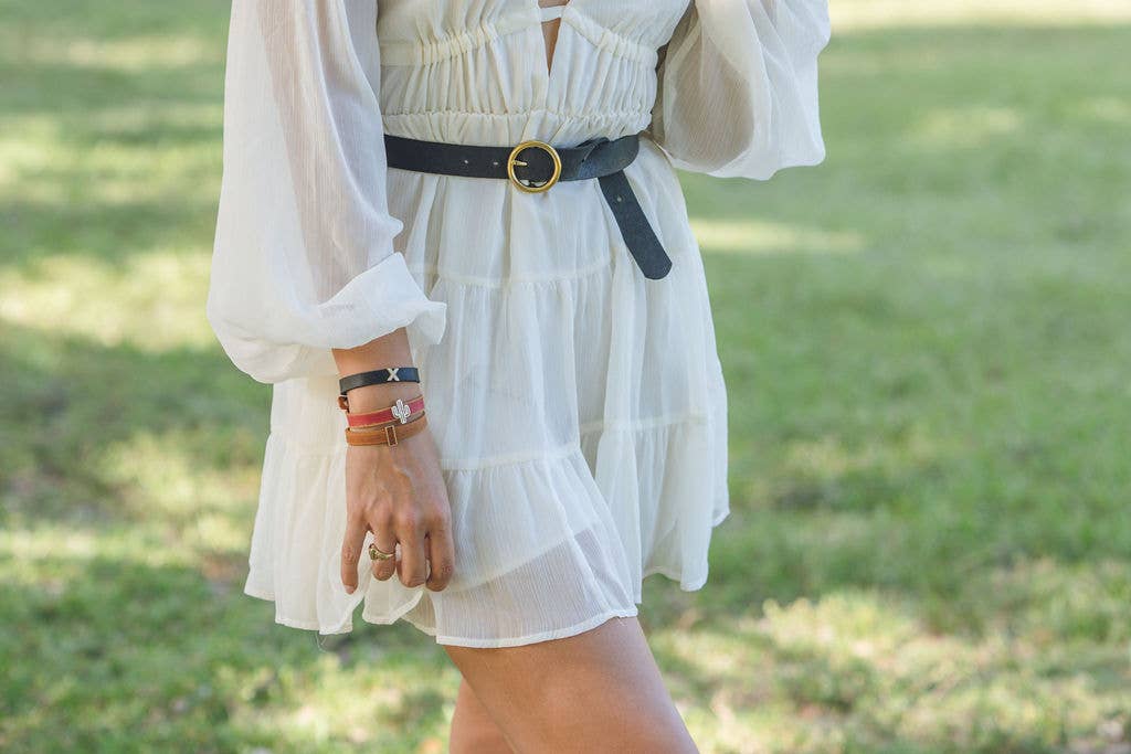 Black circle buckle belt worn over a white dress