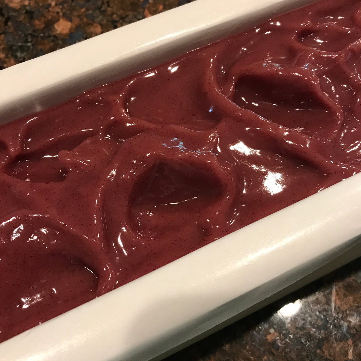 Freshly poured pink peppermint soap in a loaf mold