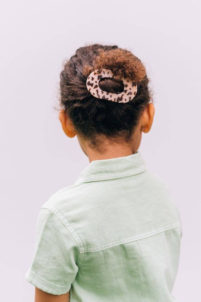 Small blonde tortoise flat clip holding a bun on a young girl