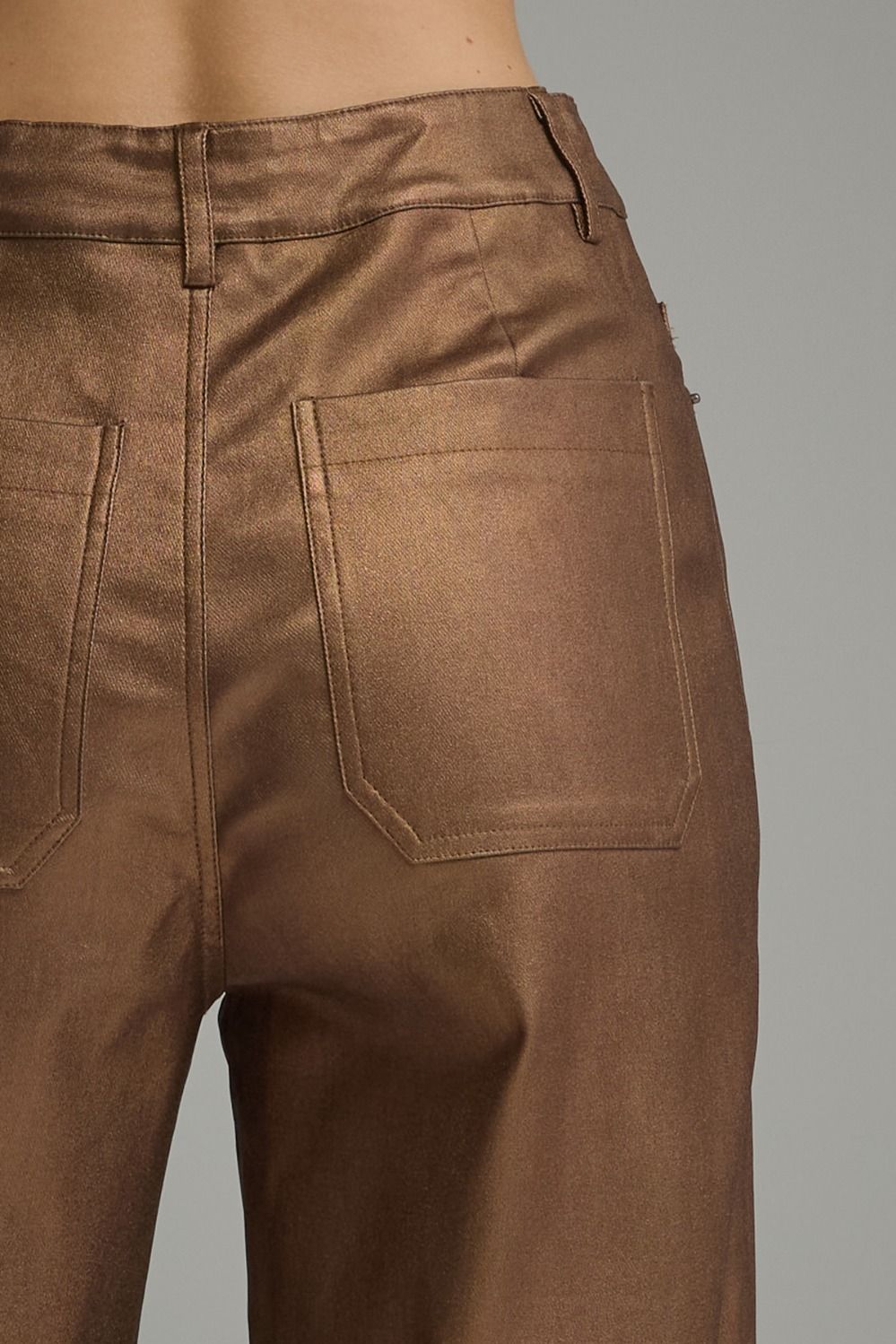 Close-up of metallic brown pants back pocket