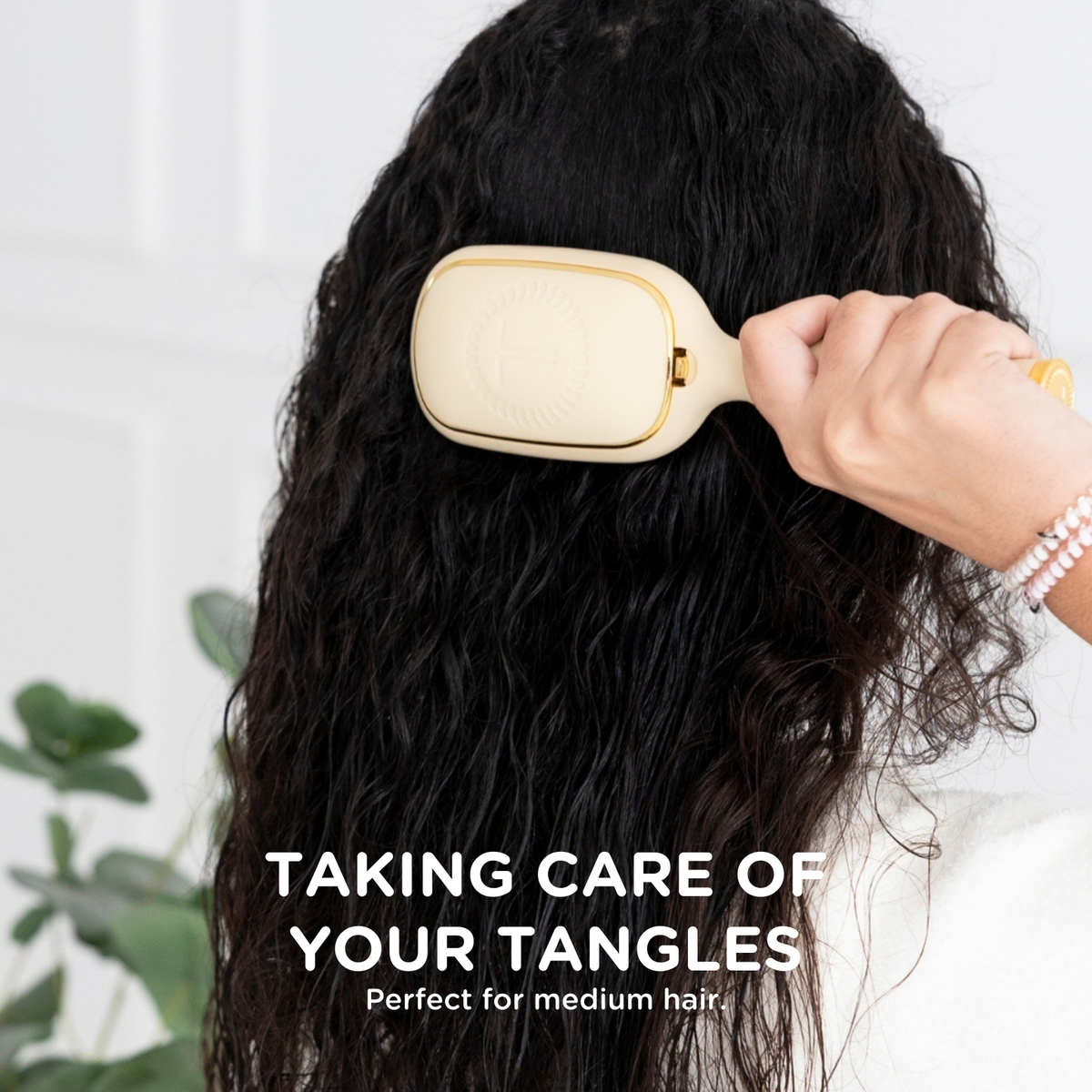Woman brushing her hair with the TELETIES detangler brush for medium hair