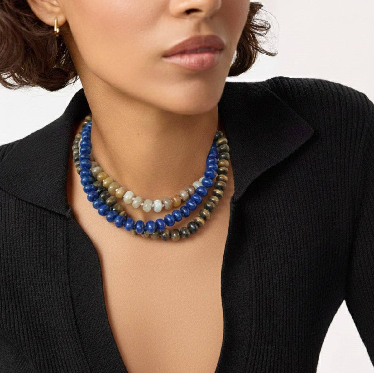 Woman wearing a multicolored beaded necklace with a black blazer.