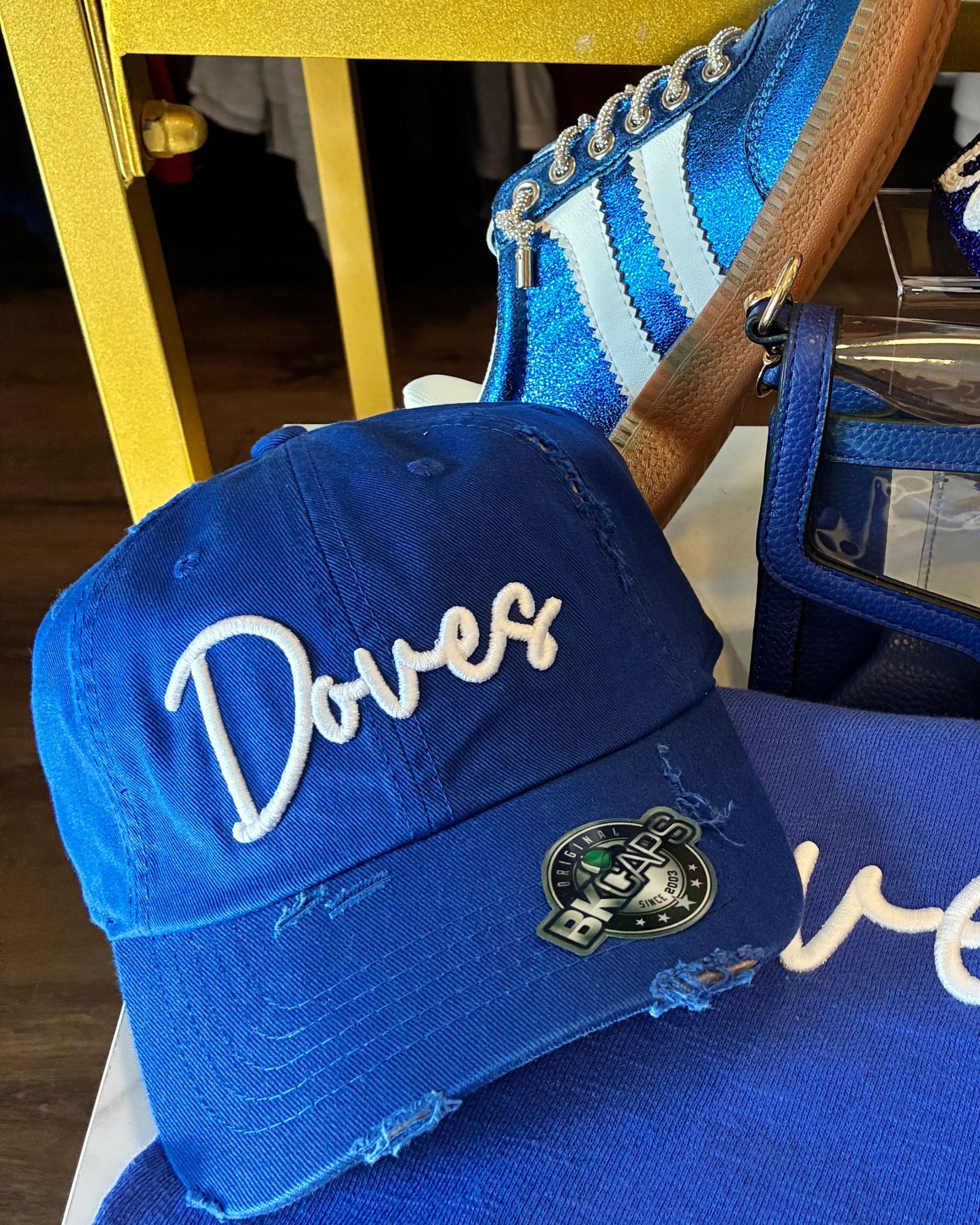 A royal blue distressed baseball cap with 'Doves' embroidered in white script