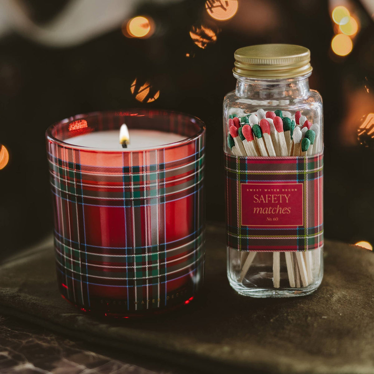Holiday plaid safety matches beside a red plaid candle