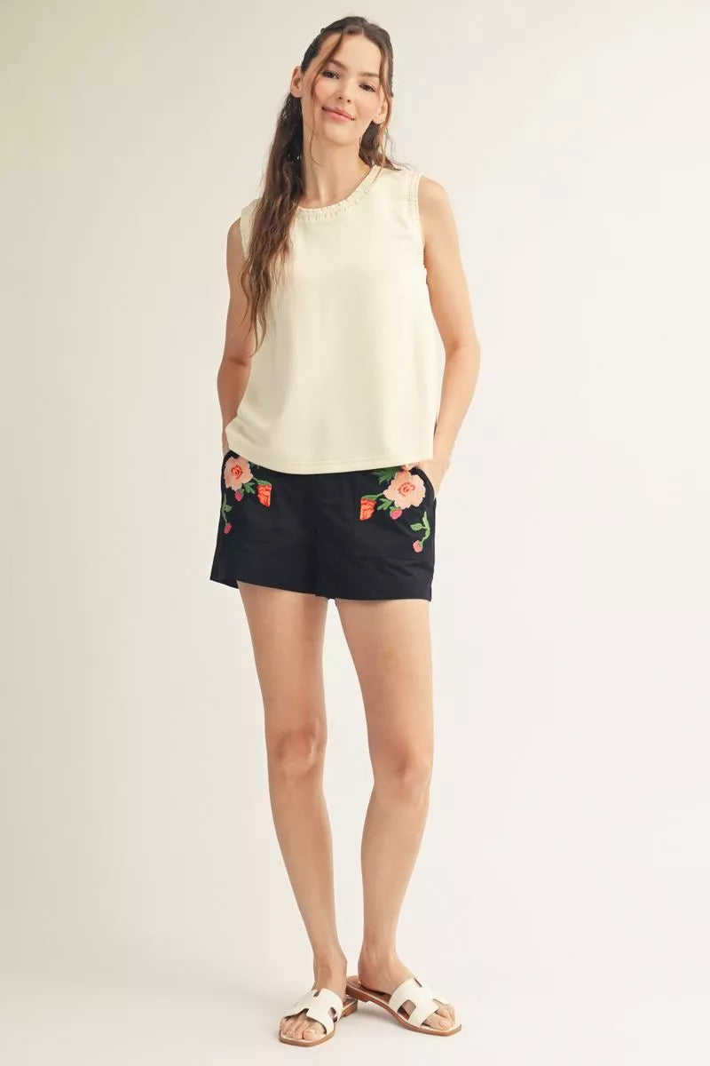 Full-length view of the ivory tank with black shorts and sandals