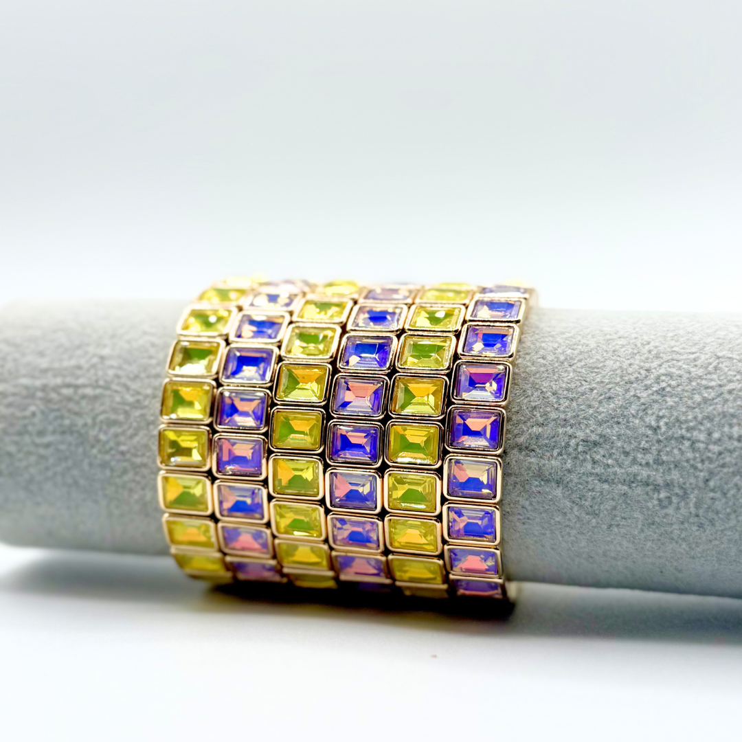 Purple and yellow square gemstone set in a gold backing on a bracelet