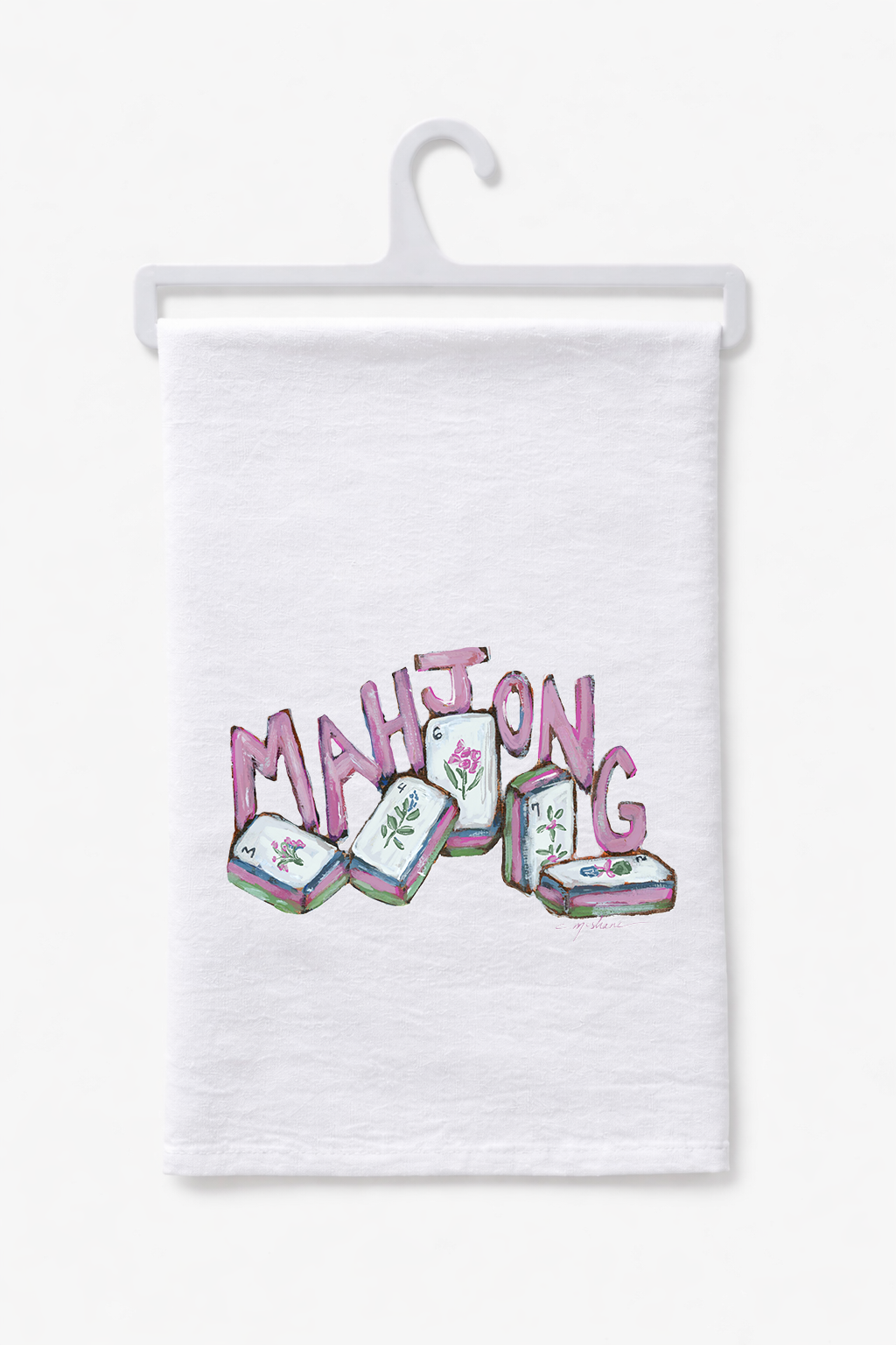 White cotton tea towel with pink MAHJONG lettering and illustrated tiles on a hanger