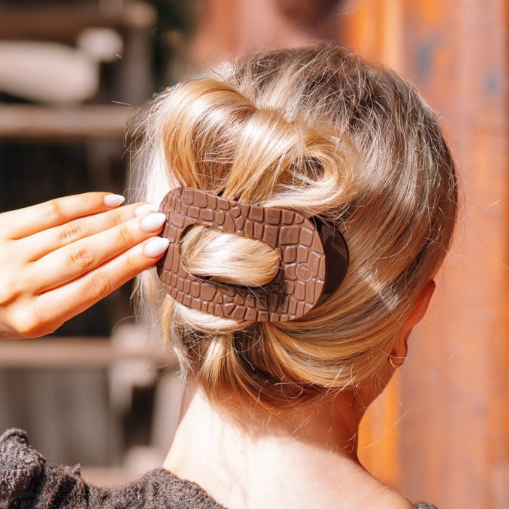Woman wearing the Brown Crocodile large flat round hair clip in a twisted updo