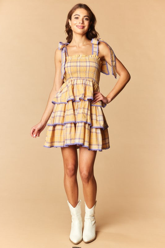 Tiered yellow, purple and white  plaid mini dress with featuring tied shoulder straps.