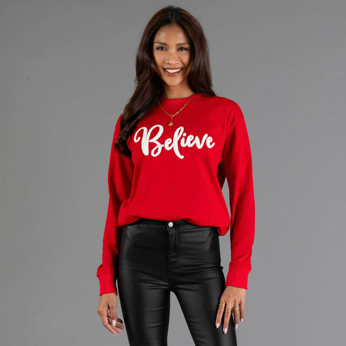 Red Believe holiday crewneck sweatshirt with white script lettering, front view