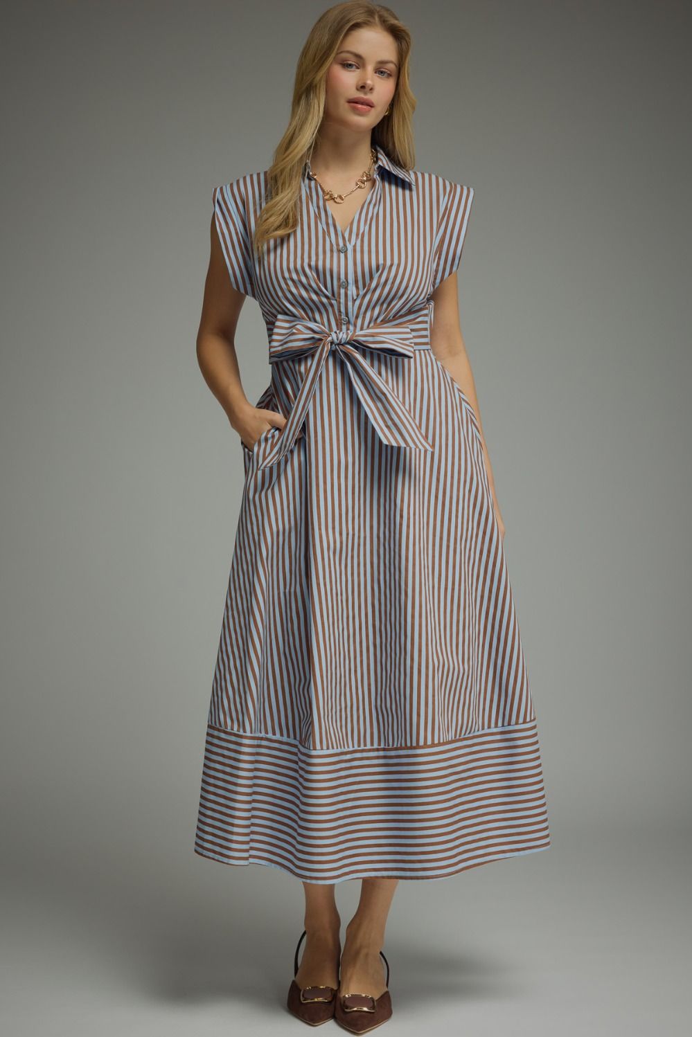 Woman wearing a striped dress against a gray background