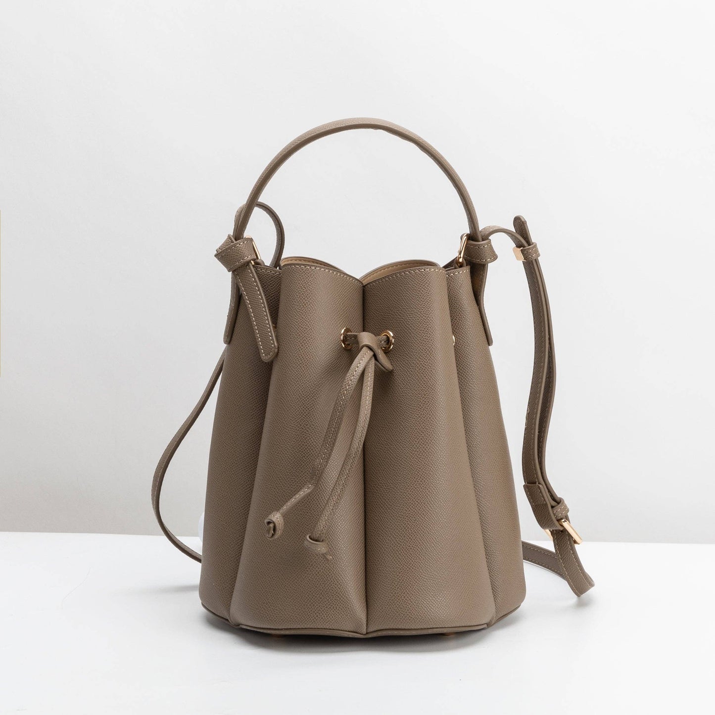 Beige leather bucket bag on a white background