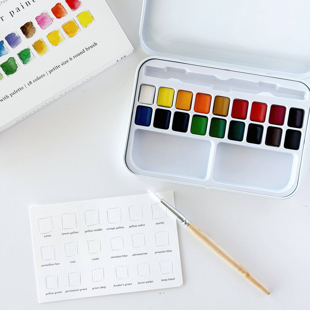 Watercolor paint tin with brush and color swatch card