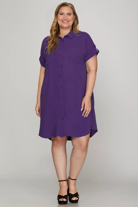 A women wearing a purple button down dress with drop shoulders 