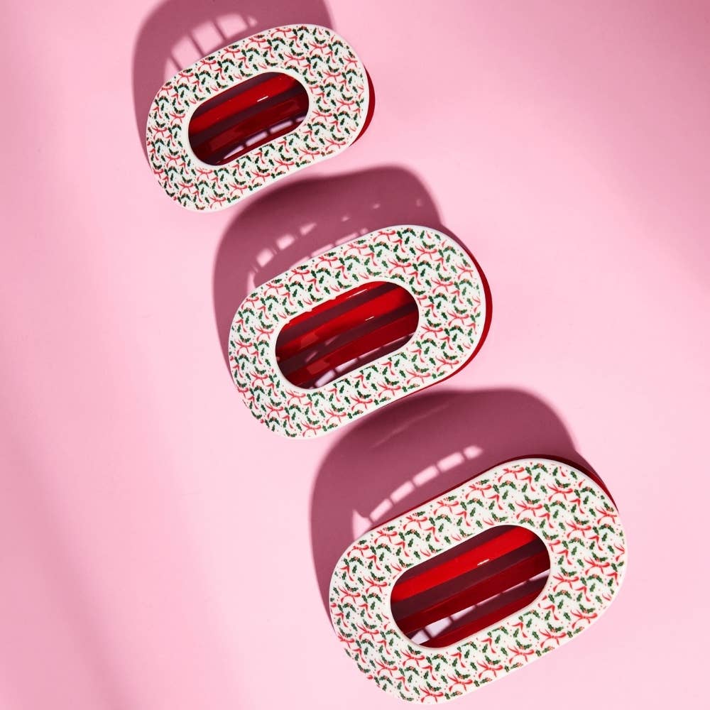 Festive Feels holly print flat clips on a pink background
