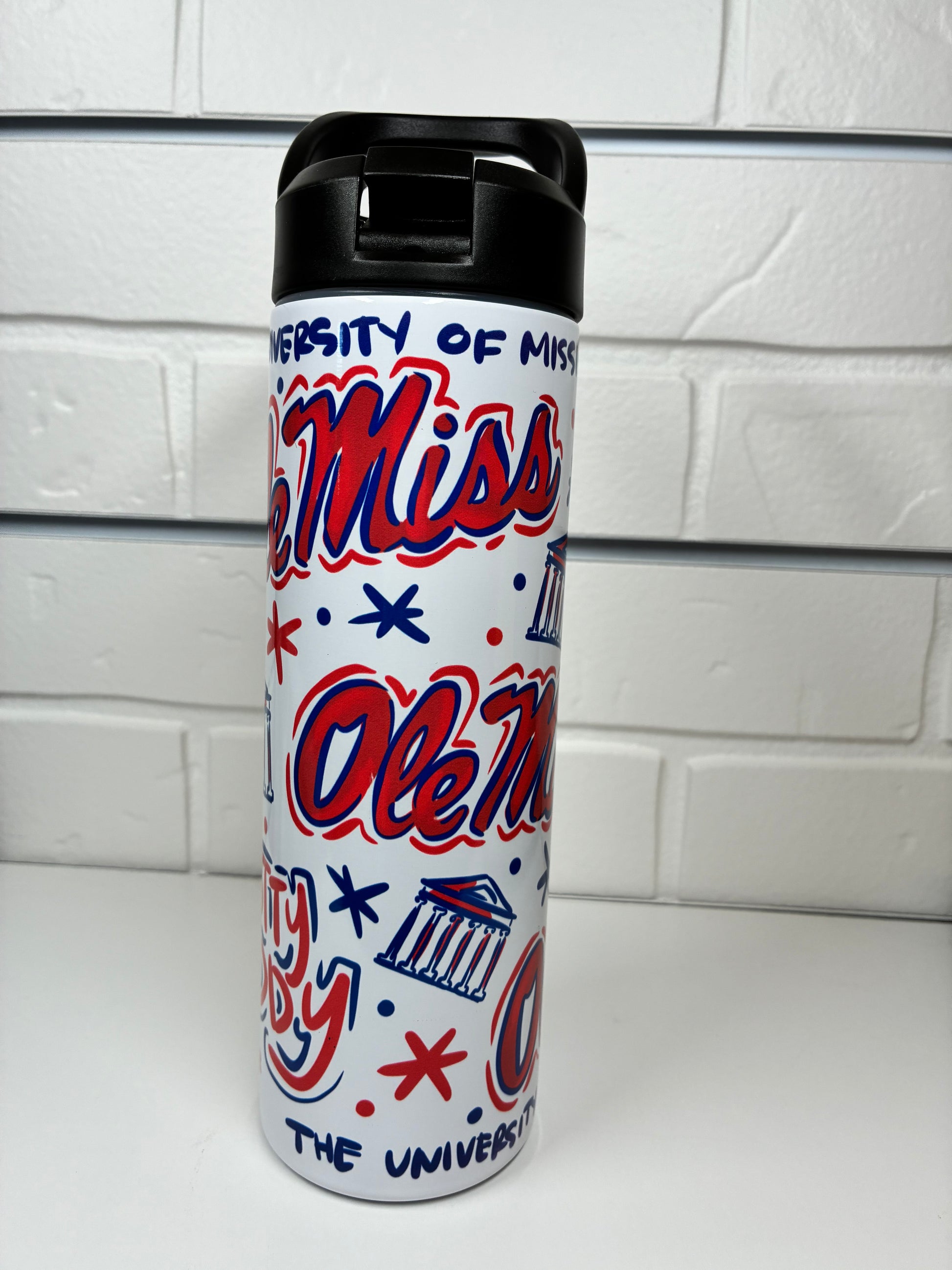 Water bottle with 'Ole Miss' design on a white tiled background