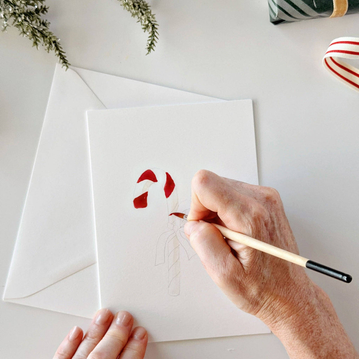 Painting a candy cane on a watercolor notecard
