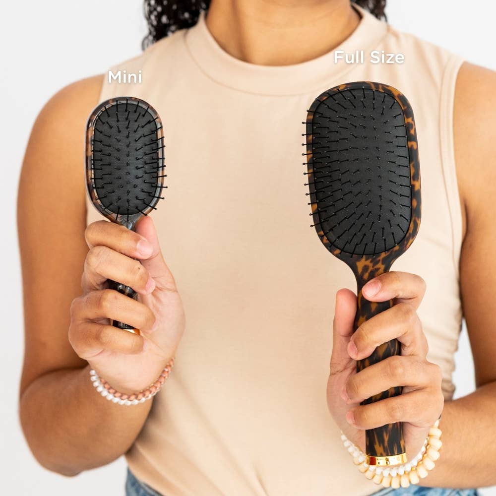 Woman holding TELETIES full size and mini brushes