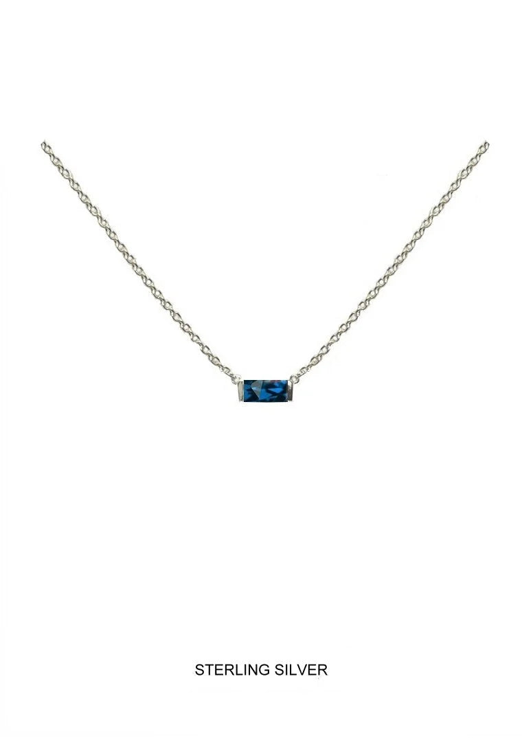 Sterling silver chain necklace with a small rectangular blue birthstone shown on a plain white background with the text 'STERLING SILVER' below.