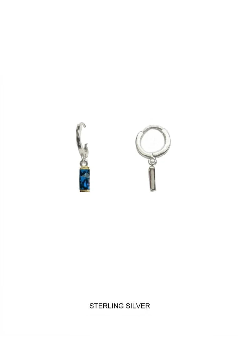 Sterling silver huggie hoop earrings shown on a plain white background, with  featuring a small rectangular blue gemstone 