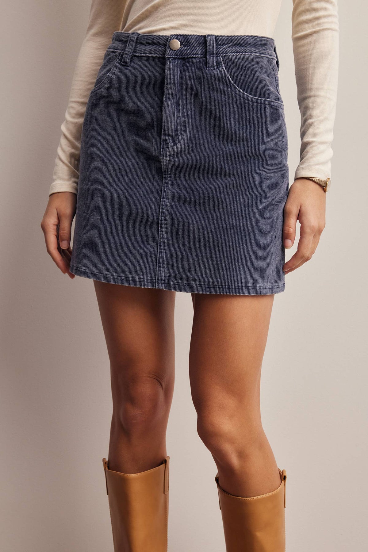 Fireside Cord Mini Skirt in faded navy stretch corduroy, front view with knee-high boots