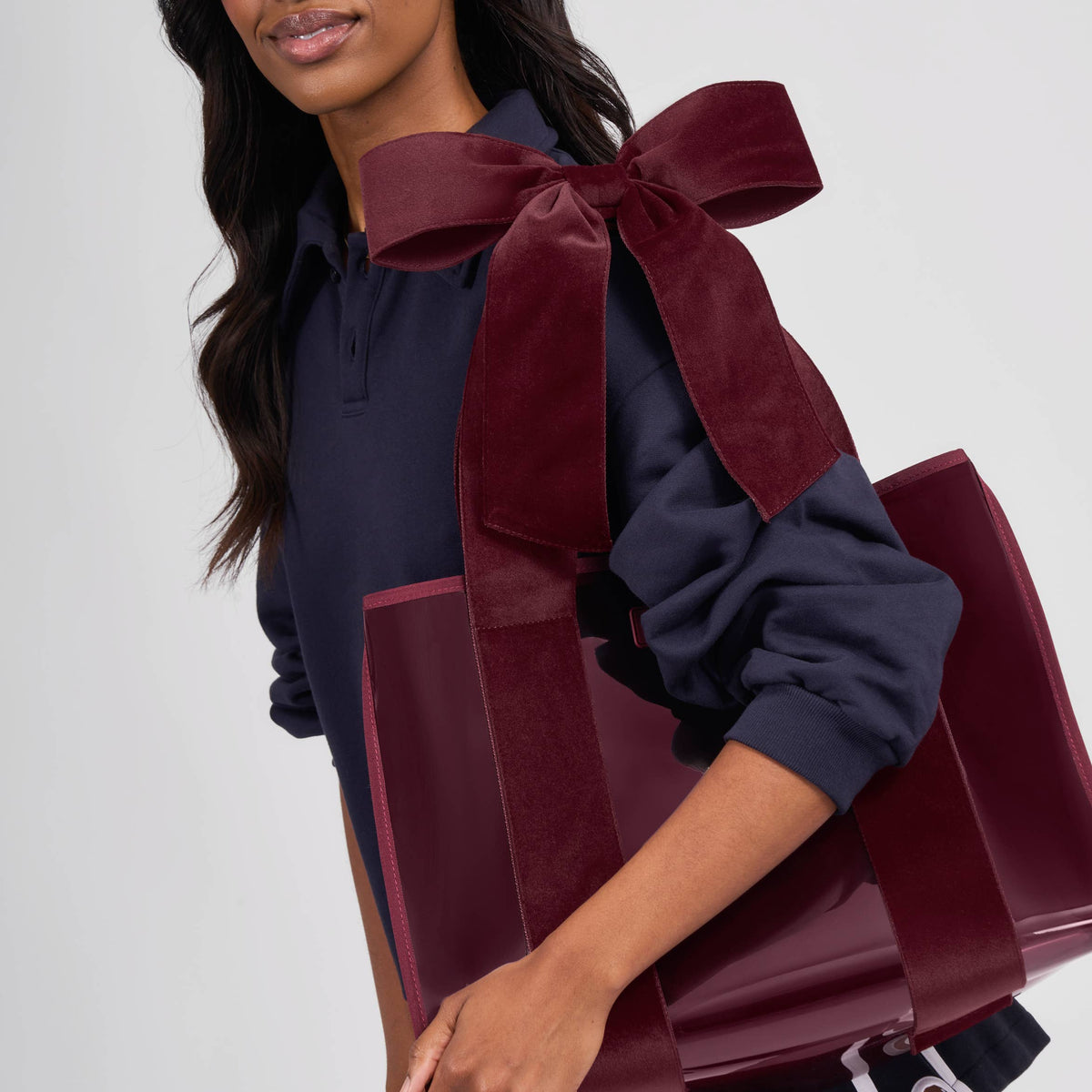 Woman carrying the red velvet bow jelly tote bag on her shoulder