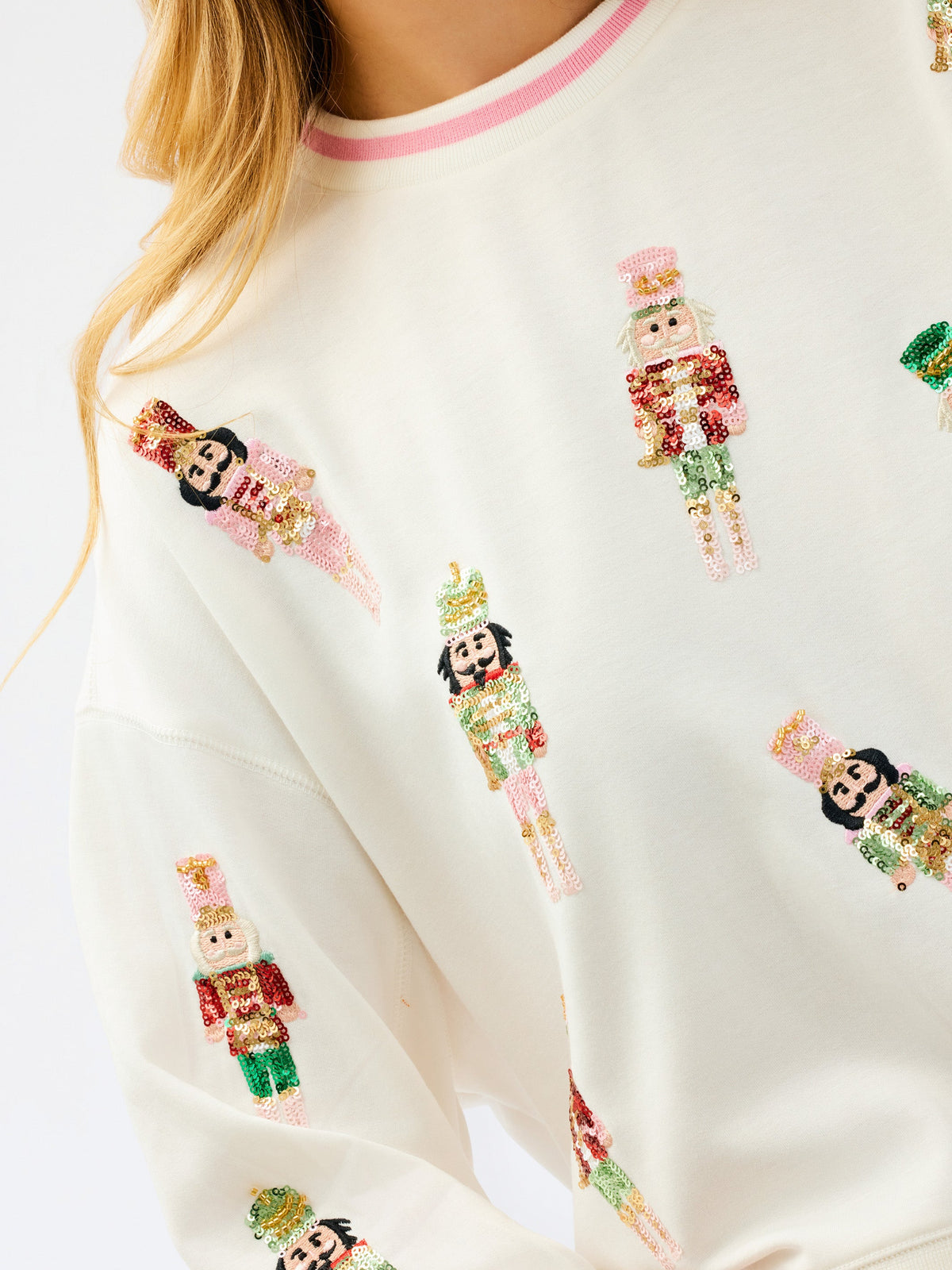 Close-up of embellished nutcrackers on ivory sweatshirt