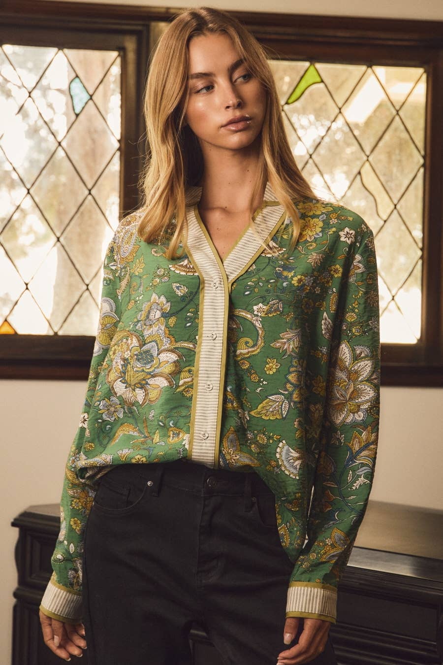 Model in the Emerald Heirloom Blouse, a green paisley button-front top with cream striped trim