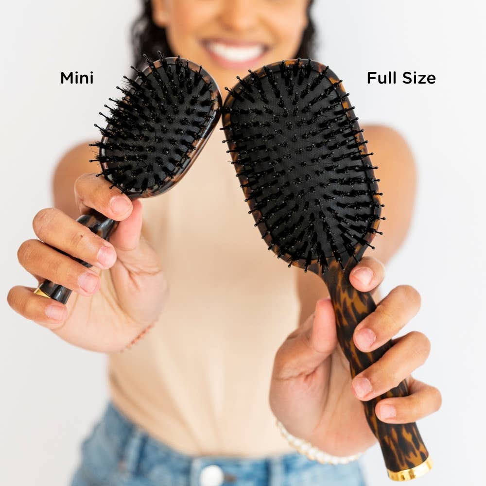 Woman holding TELETIES full size and mini brushes