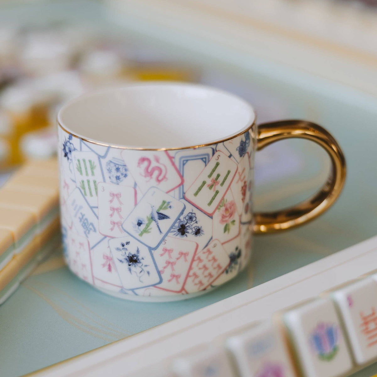Mahjong tiles mug with a gold handle on a Mahjong table
