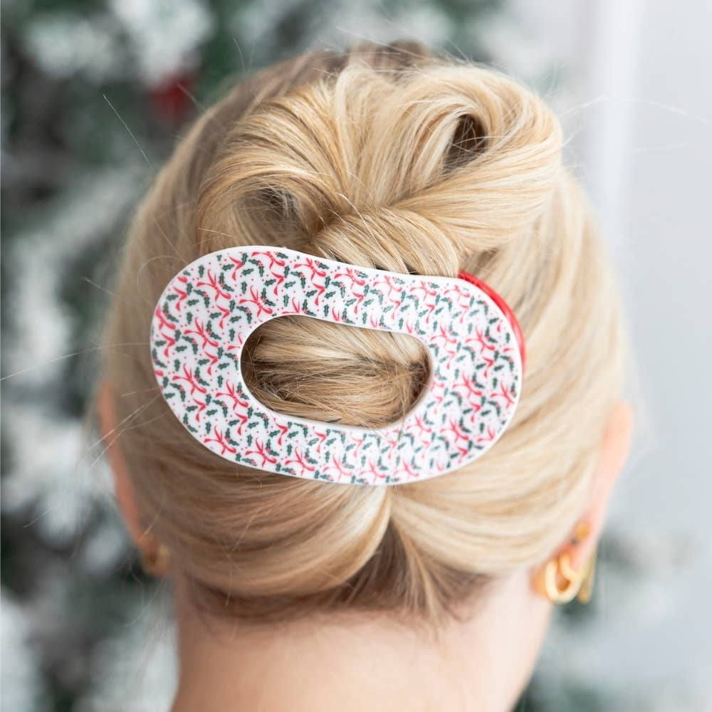 Woman wearing the Festive Feels holly print medium flat round hair clip in an updo