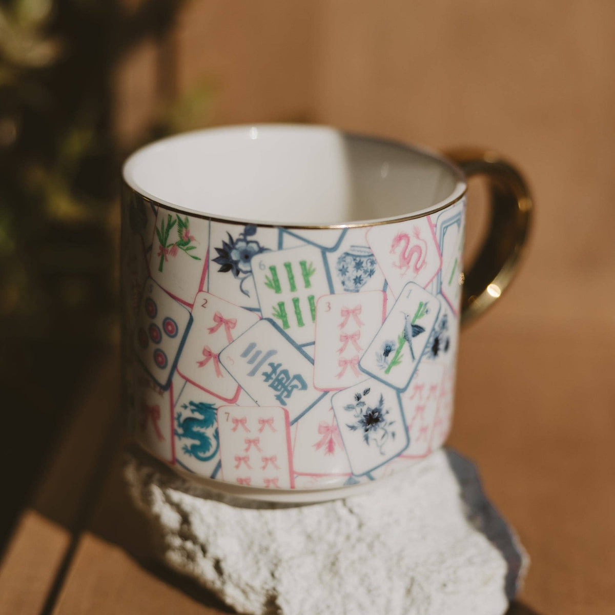 Mahjong tiles coffee mug in sunlight on a stone