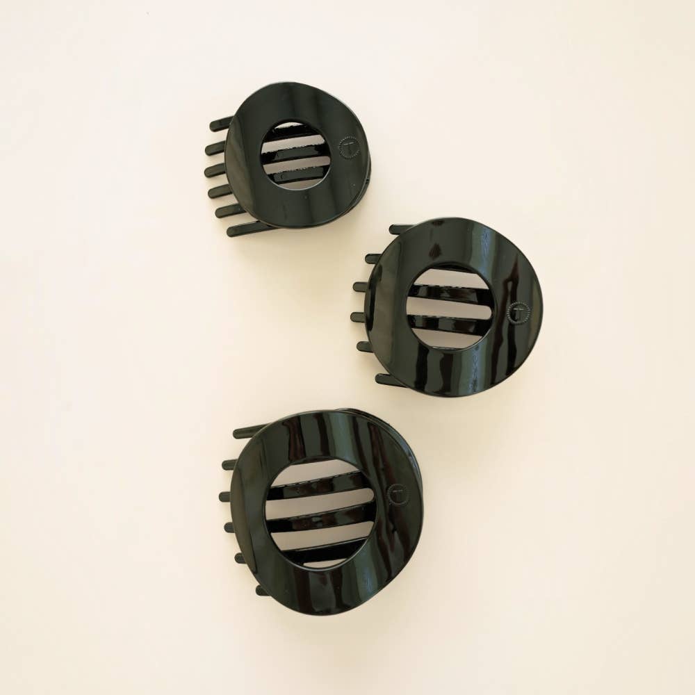 Three Jet Black flat circle hair clips grouped together