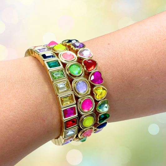 Multicolored gemstone bracelet on a wrist with a blurred light background
