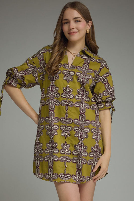 Woman wearing a green patterned dress against a gray background
