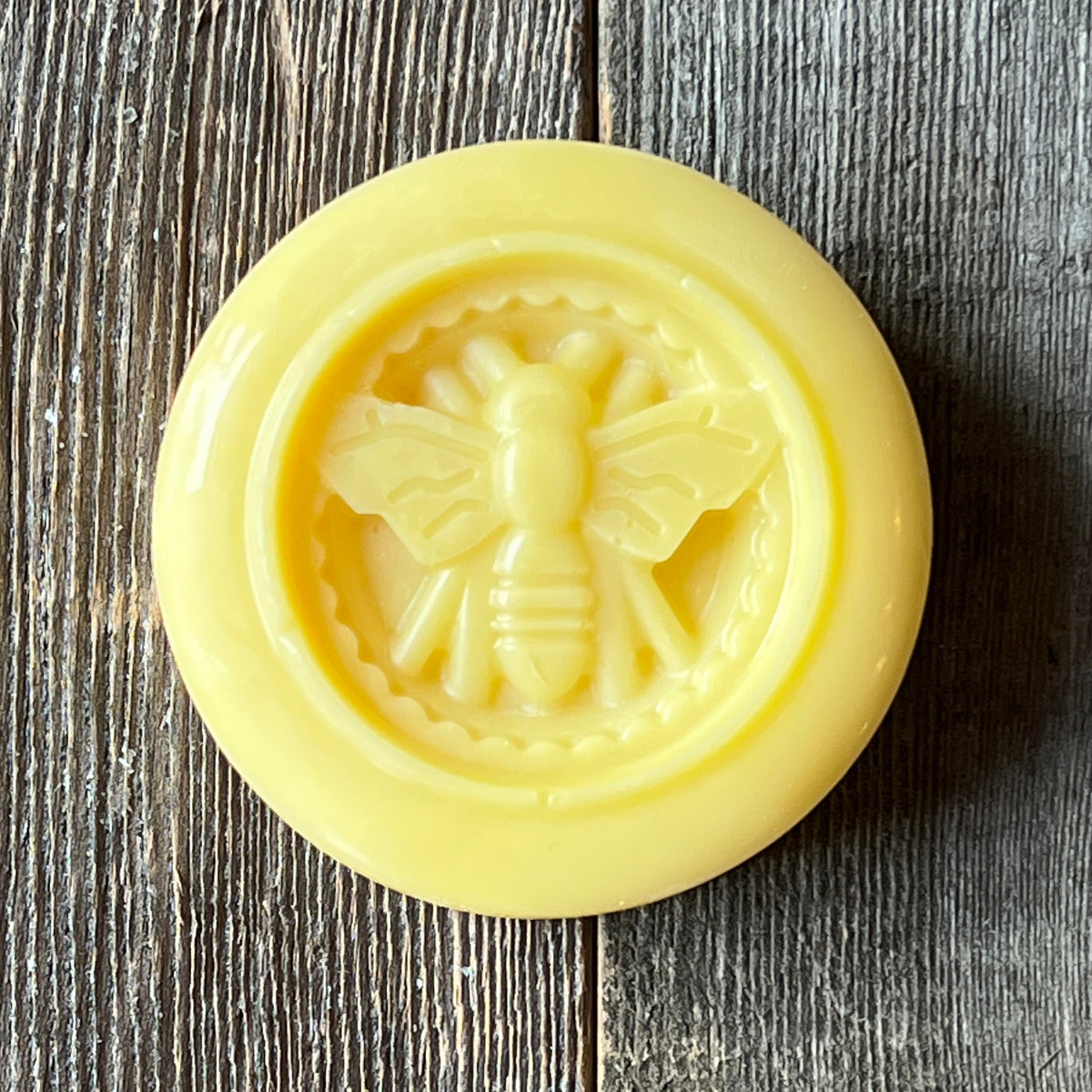 Golden lotion bar stamped with a honeybee design