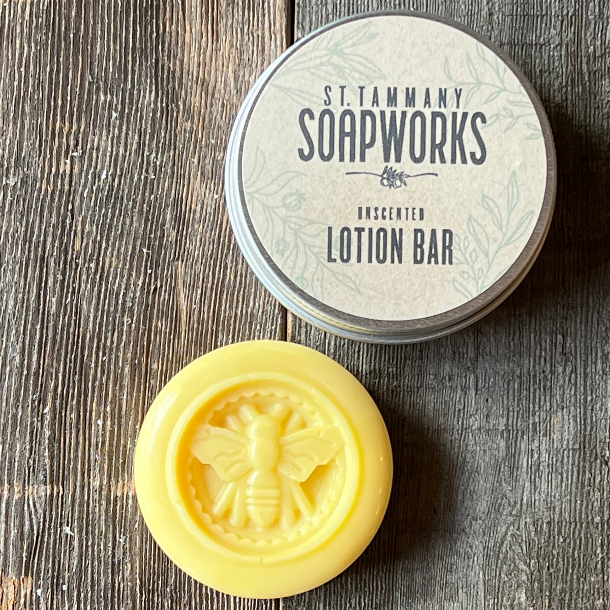 Honeybee lotion bar sitting beside its silver tin