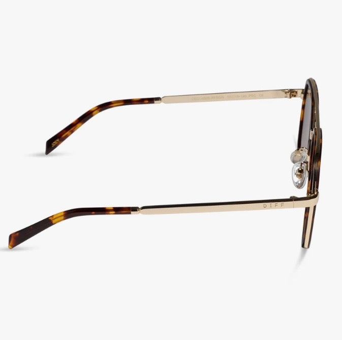 Sunglasses featuring a gold metal frame and temples with a classic tortoiseshell pattern, shown from a side profile view against a light gray background.