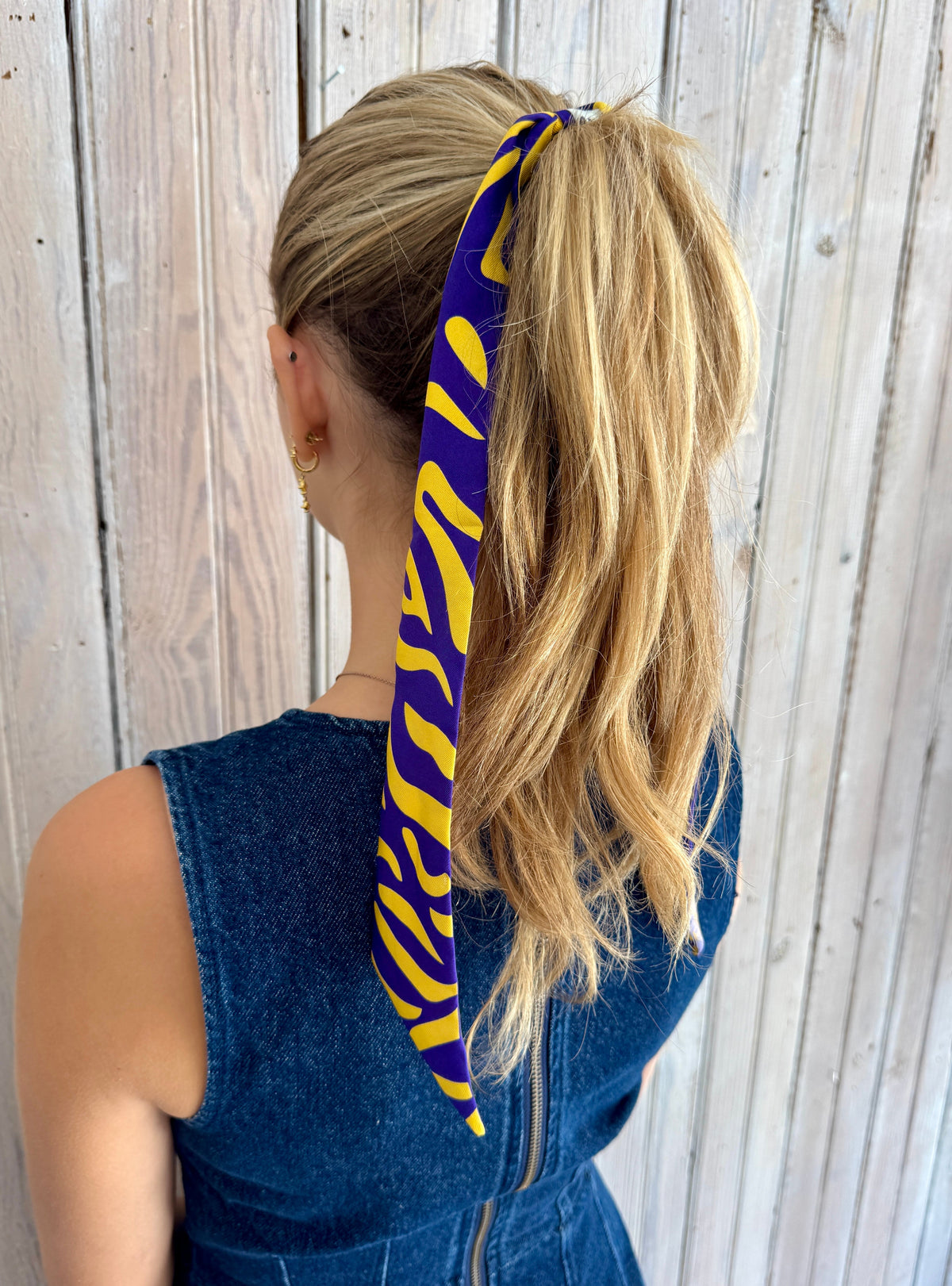 Purple and gold tiger stripe twilly scarf wrapped around a ponytail