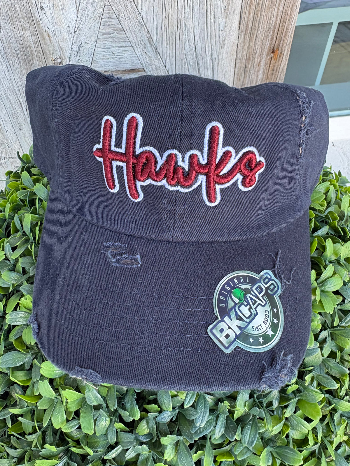 Navy blue hat with puff crimson Hawks outlined in white 