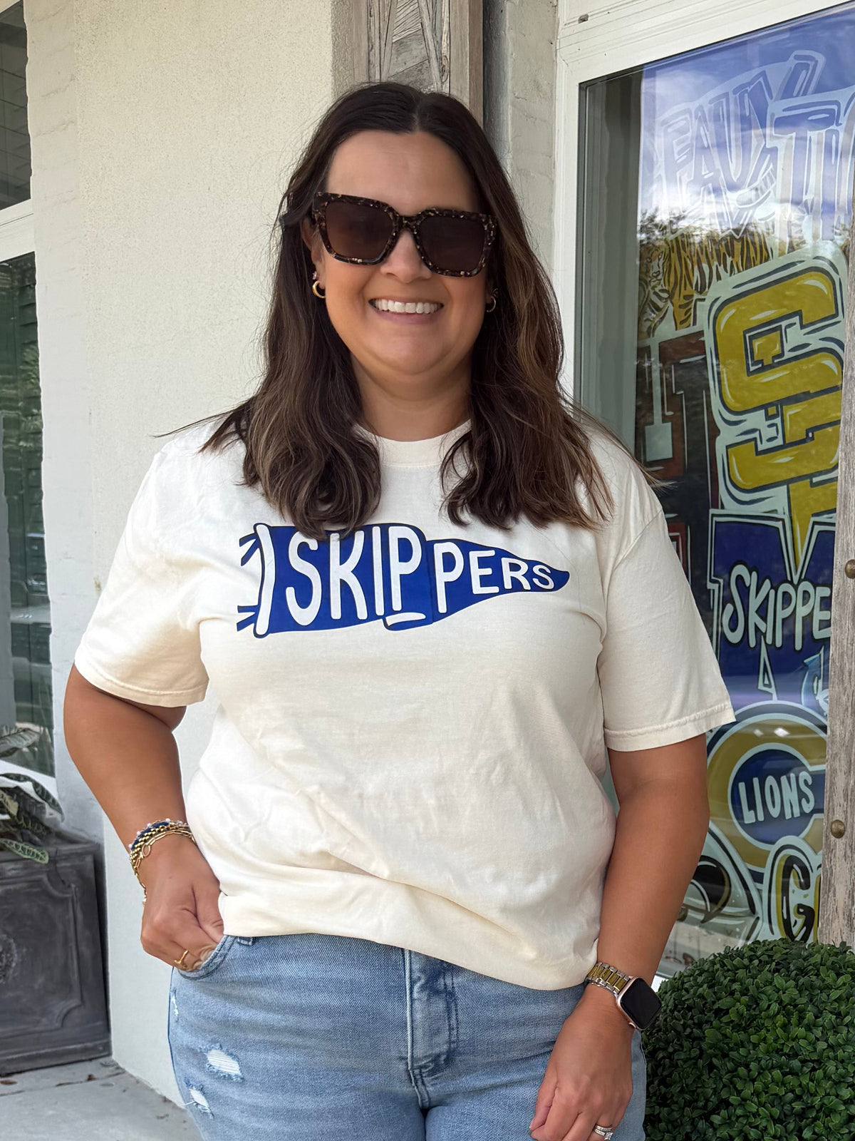 Ivory color T shirt with a Pennant Flag that says Skippers