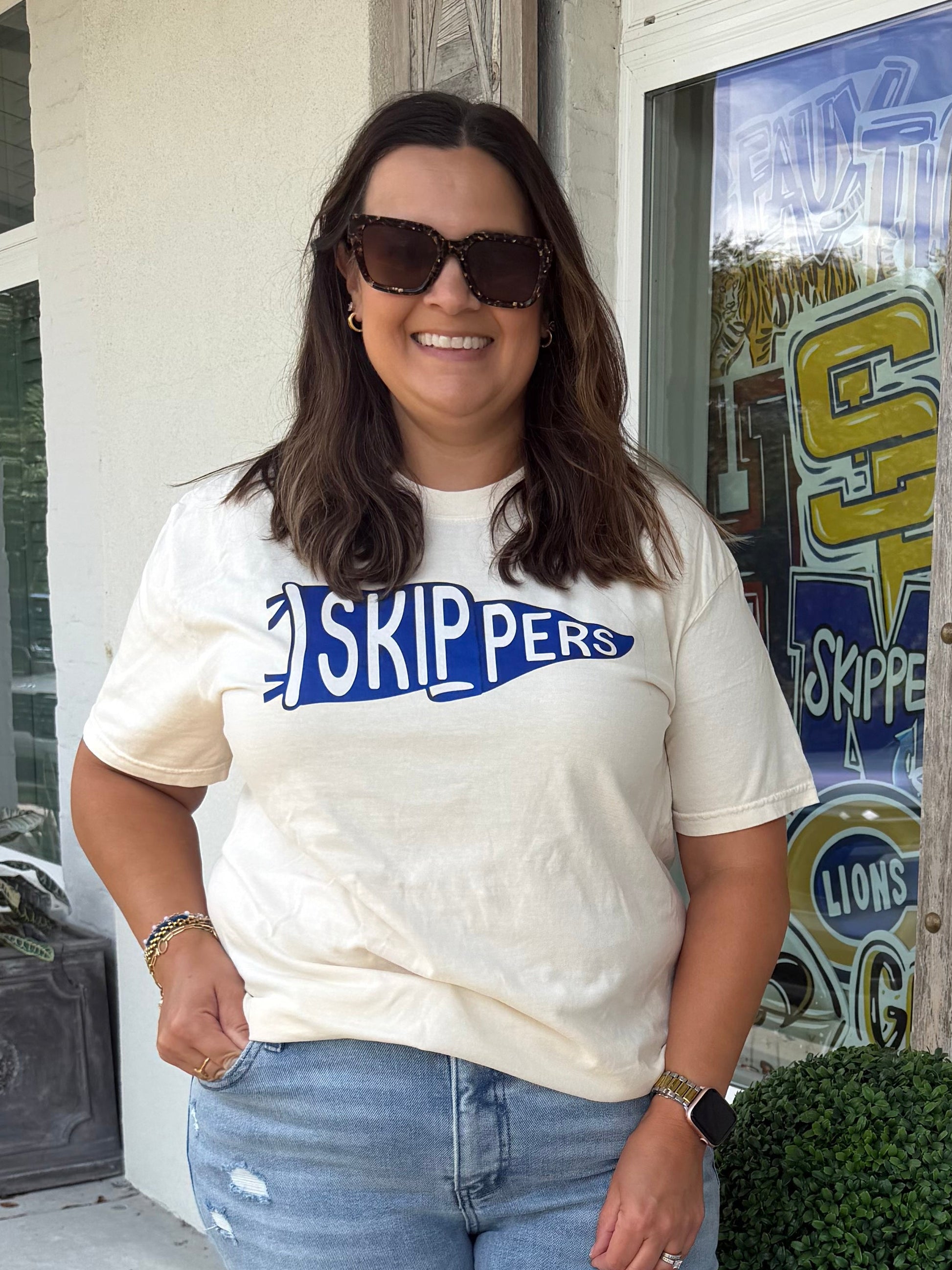 Ivory color T shirt with a Pennant Flag that says Skippers
