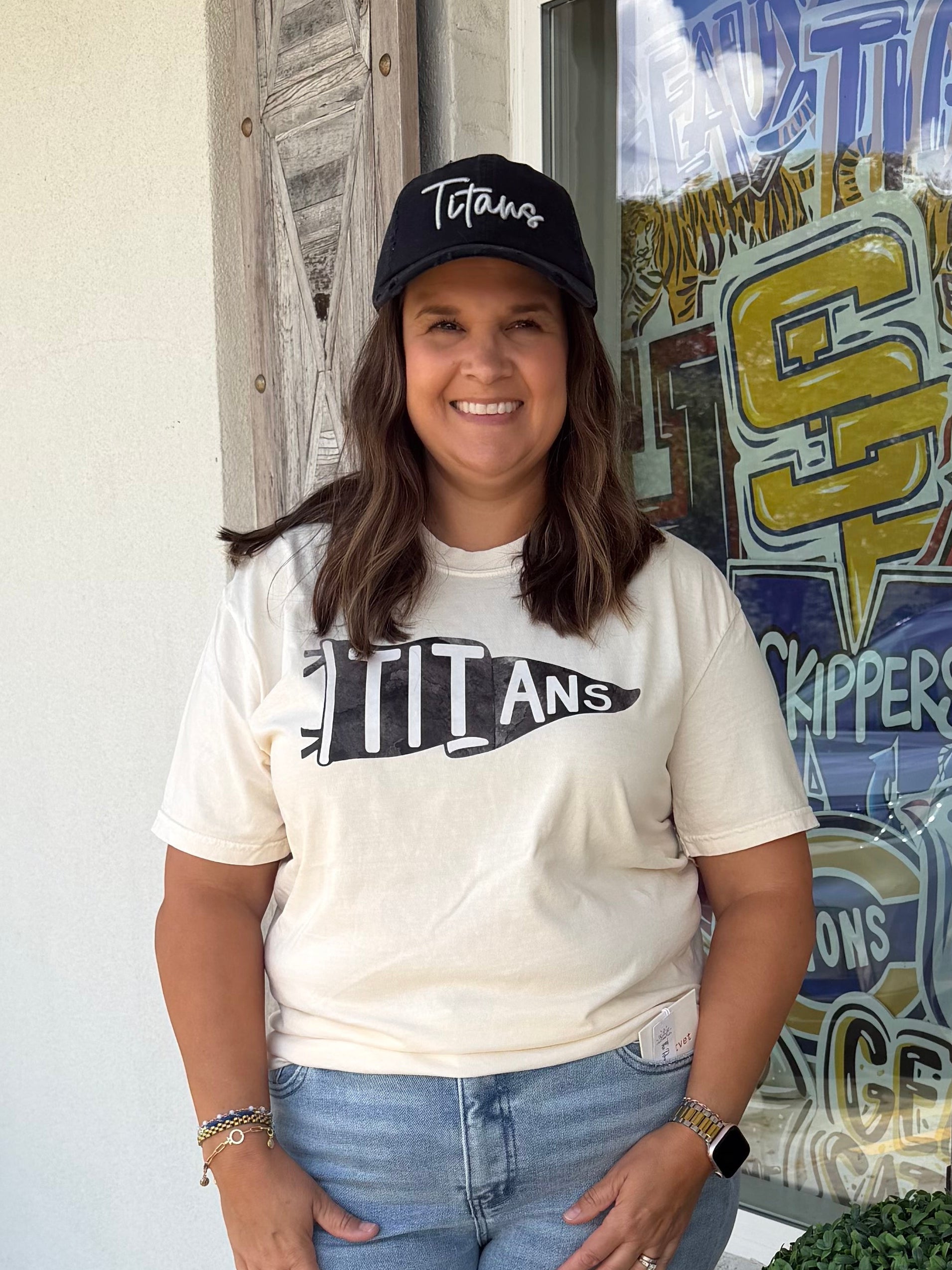 A women wearing an Ivory color t shirt with graphic pennant flag that says titans