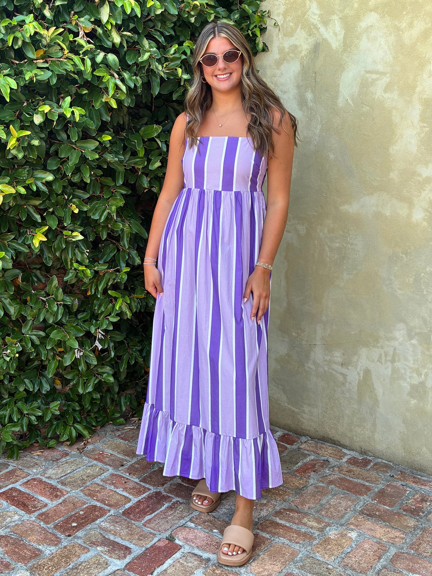 young lady in a purple, lavender, and white striped maxi dress
