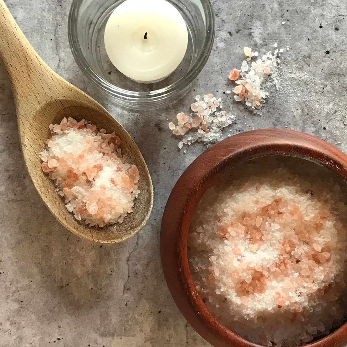Wooden spoon and bowl of pink and white RELIEVE bath salts