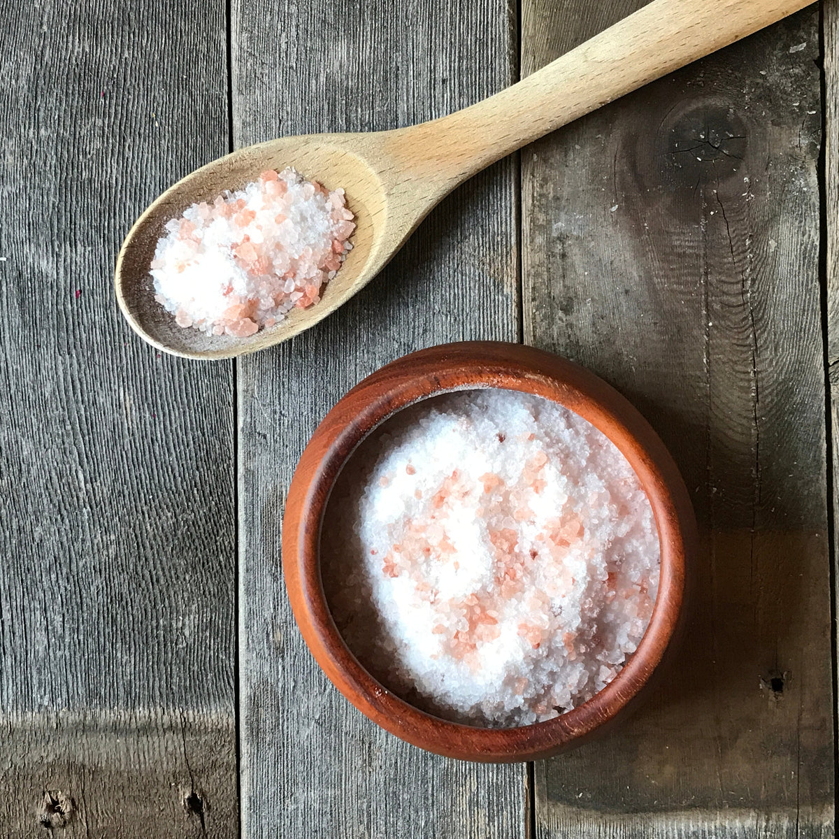 Wooden spoon and bowl of pink and white RELAX bath salts
