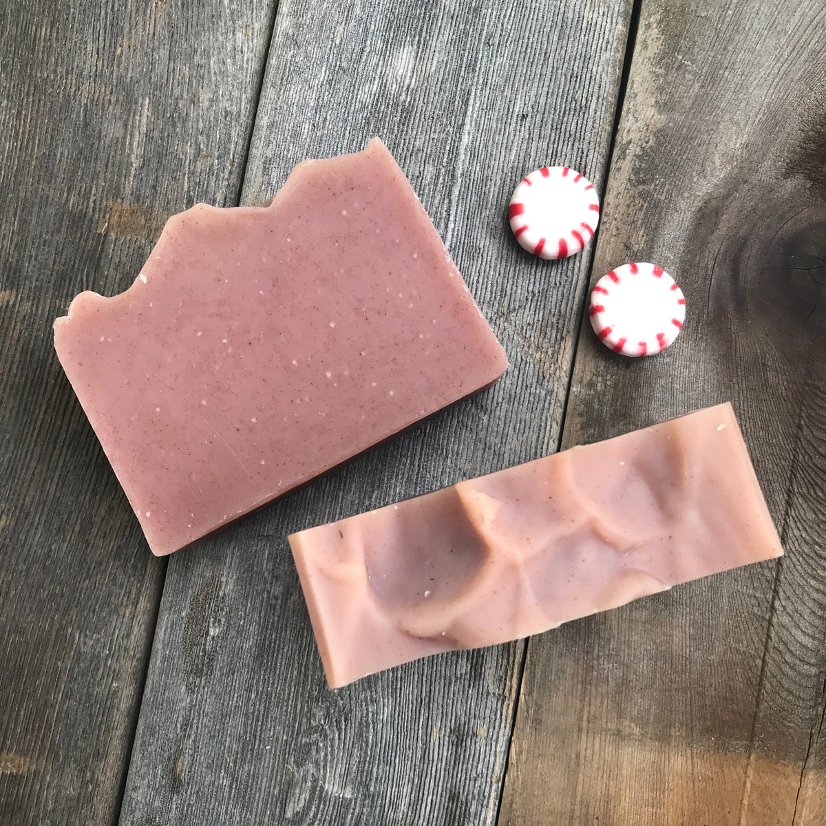 Two rosy pink Mad Peppermint soap bars with peppermint candies