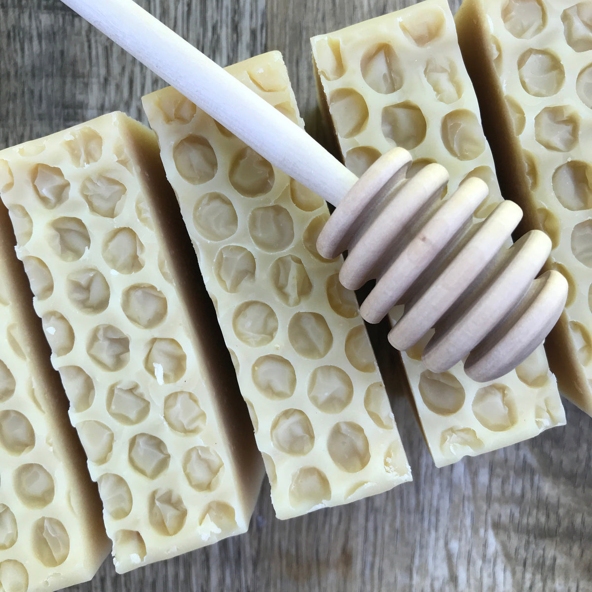 Row of oatmeal honey soap bars with a honey dipper